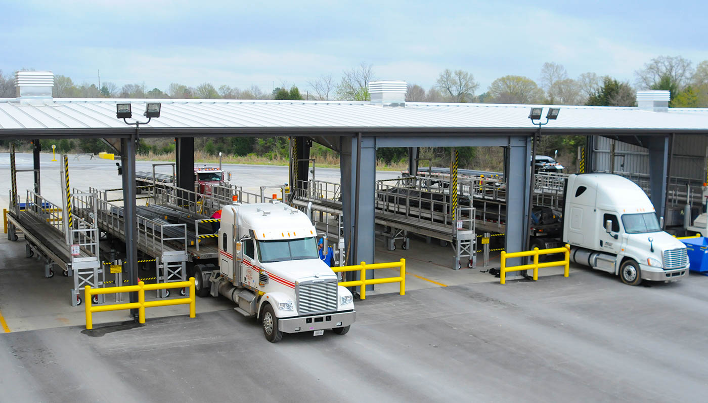 Flatbed trailer loading facility increases throughput by improving safety.